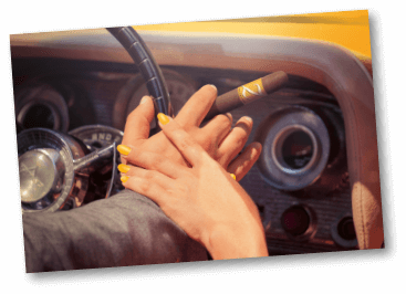 Paar händchenhaltenden in einem alten Auto. Die andere Hand des Mannes am Lenkrad, hält eine Zino Nicaragua Zigarre.